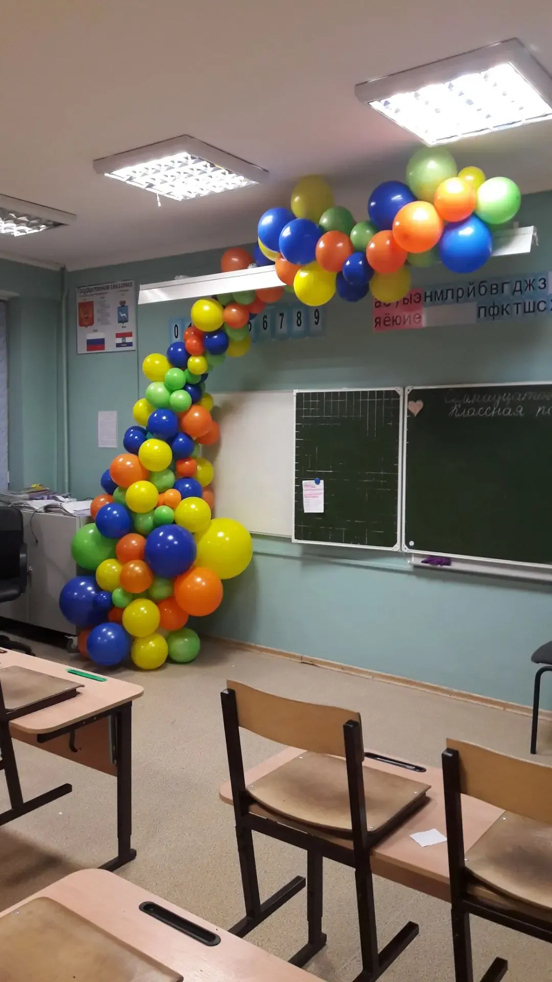 «Радужная гирлянда над школьной доской» — композиция целиком: пропорции рассчитаны под зал и фотозону. Сделаем похожий набор под вашу дату — оставьте заявку, всё посчитаем заранее.